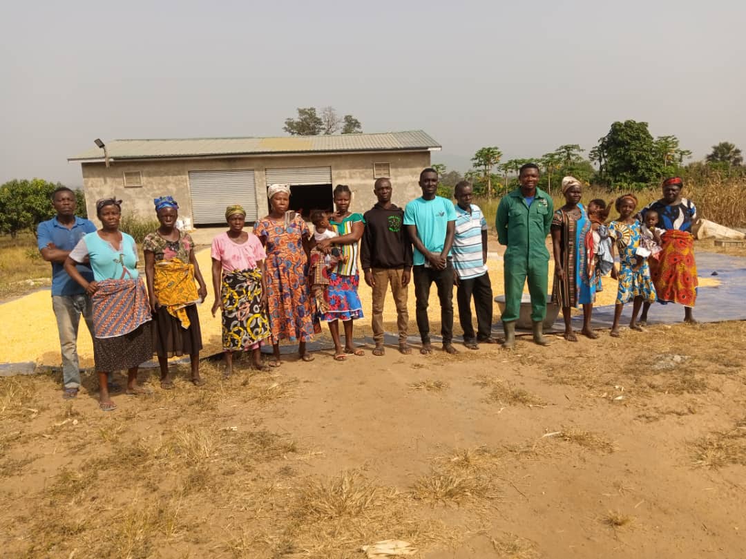 A group of farmers and project team members standing in a line in front of a building, image 7 of 10