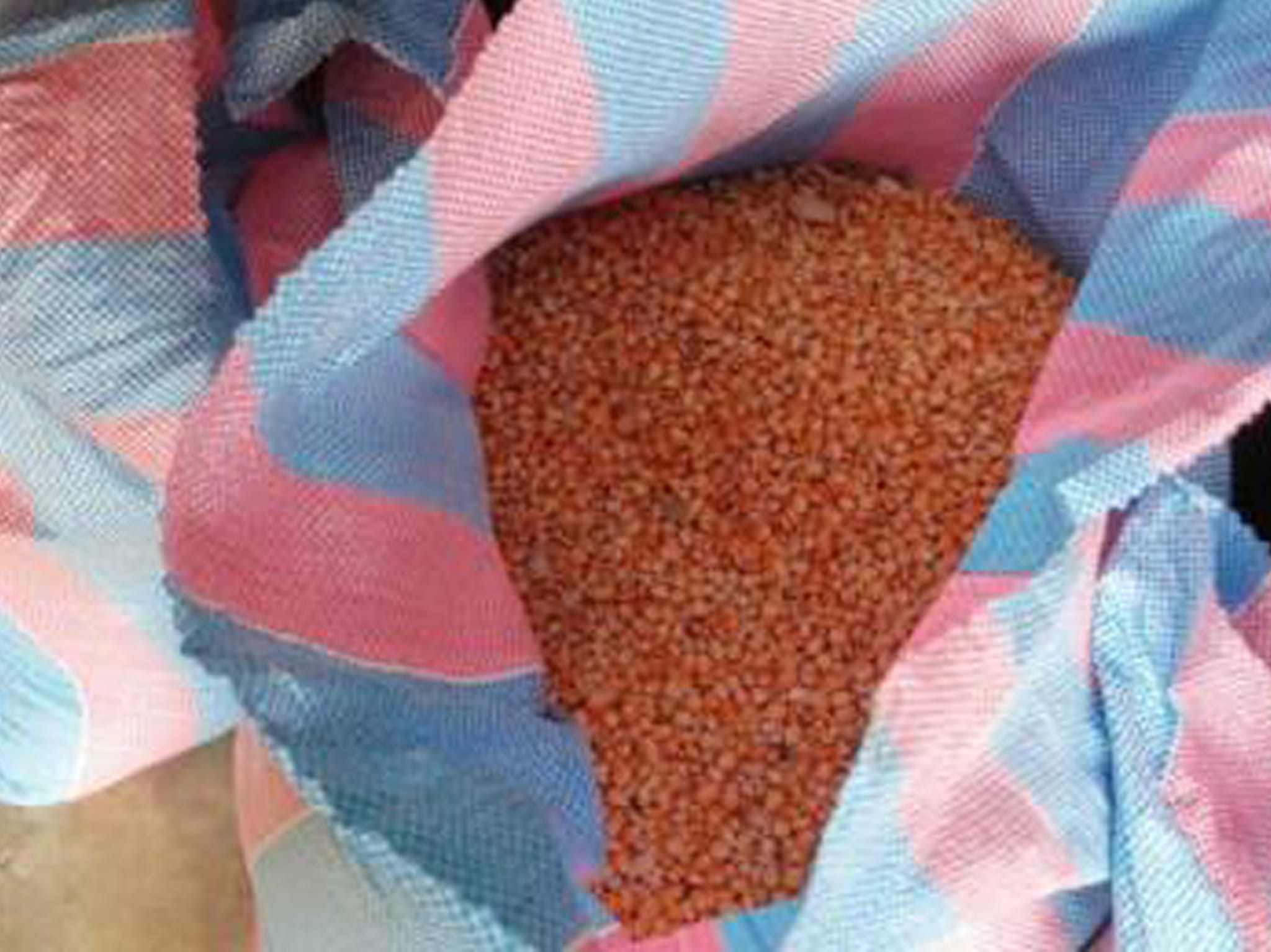Small reddish seeds in an open woven sack, image 6 of 10